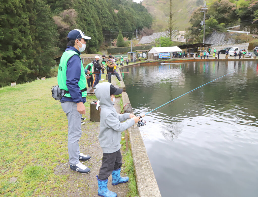日本釣振興会大阪府支部の千早川ルアー釣り体験教室の、指導する橋本支部長と参加者の子供