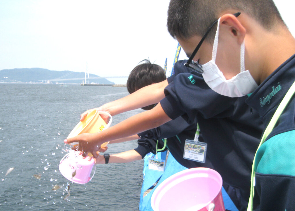 日本釣振興会兵庫県支部のマコガレイの放流に参加した中学生
