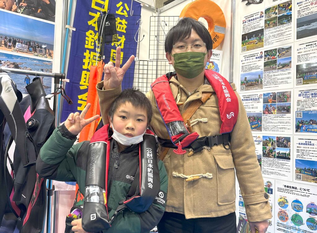 キープキャストの日本釣振興会愛知県支部ブースでライフジャケットのモデルをする親子