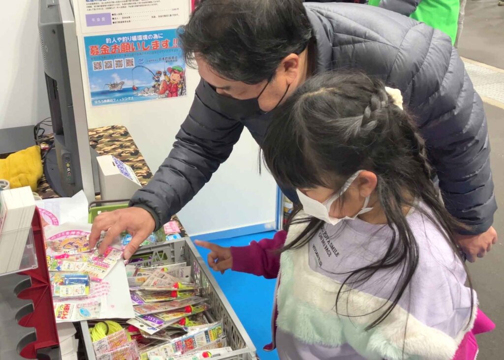 キープキャストの日本釣振興会愛知県支部ブースで賞品を選ぶ親子