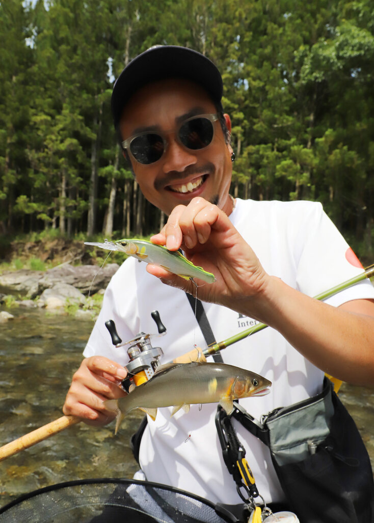 良型のアユを釣るデュオの萩原さん